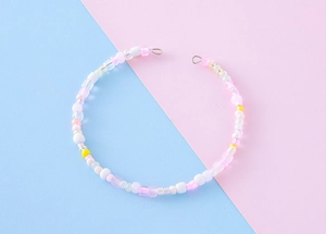 Detail of handmade macaron beaded necklace with pink and white resin beads