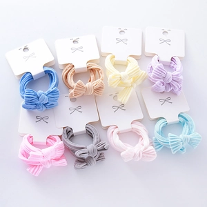 Detail of 8 pieces macaron colored bow hair ties with elastic towel rings on white cards