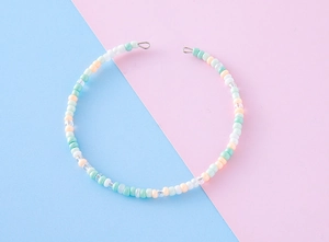 Close-up of handmade colorful seed bead chain with white, mint green and orange beads