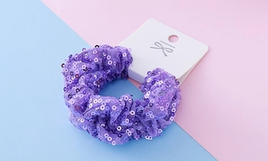 Detail view of purple sequined scrunchie with sparkling mesh fabric on display card