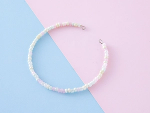 Detailed macro of handmade colorful bead bracelet featuring pink and pearlescent white beads
