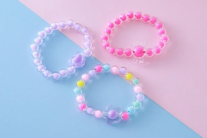 Detalle del juego de tres pulseras de cuentas para niños con colgantes de corazón, caramelo y flor