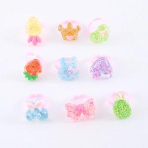 Set di 9 anelli per bambini in resina glitterata con forme di corona e frutti