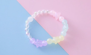 Détail de perles pastel avec breloques étoiles sur un fond géométrique coloré