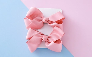 Détail de nœuds à cheveux en ruban gros-grain rose sur carte de présentation fine