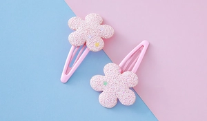Details von rosa Blumen-Haarspangen mit matter Textur und bunten Sternenmustern