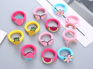 Vue à plat d'élastiques à cheveux colorés pour enfants avec fruits et fleurs mignons