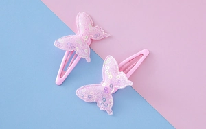 Detail von rosa Schmetterling-Haarspangen mit funkelnden Pailletten für Kinder