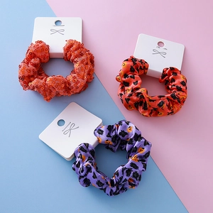 Halloween scrunchies set featuring orange sequins and spooky pumpkin prints on card