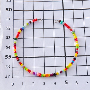 Fashionable colorful handmade bead chain with silver clasps on a white grid background