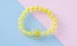 Detalle de la pulsera de flores de acrílico de colores con cuentas transparentes y centro amarillo