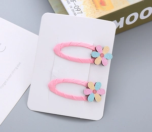 Dettaglio di graziose mollette per bambini in tessuto rosa con fiori luccicanti