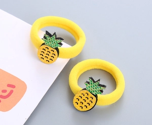 Détail d'élastiques à cheveux jaunes extensibles avec breloques ananas et paillettes