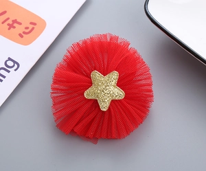 Detailed view of red mesh hair accessory with a gold glitter star and pleated layers
