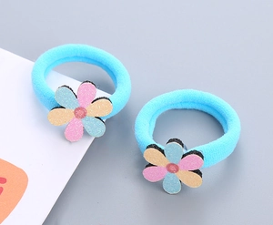 Détail de chouchous bleus en éponge avec breloques fleurs pailletées pour enfants