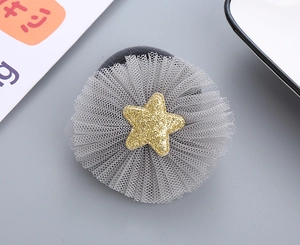 Detail of grey mesh tulle flower hair tie with a sparkling golden glitter star charm