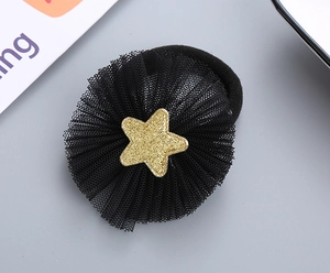 Detail showing a black mesh hair tie with a sparkling gold star sequin for children