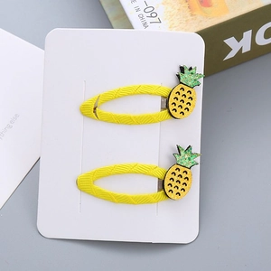Set di due fermagli per capelli per bambini con ananas giallo su cartoncino bianco deco