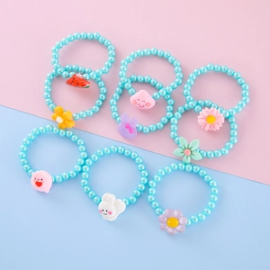 Close-up of children's beaded bracelets featuring colorful resin charms and pearl beads
