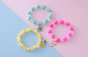 Detail of beaded bracelets featuring crackle pearls, seahorse and starfish pendants