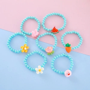 Detail of blue beaded kids bracelets with cute resin bunny and flower charms