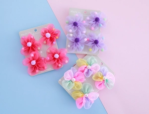 Detailansicht der handgefertigten Organza-Blüten-Haarspangen auf weißen Pappkarten