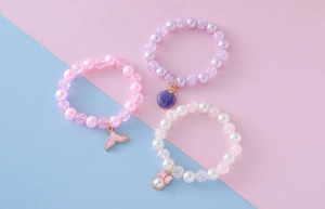 Close-up of children's beaded bracelets set with seahorse and shell pendants