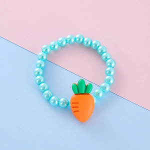 Detail of blue beaded bracelet with an orange carrot charm for kids on pastel background
