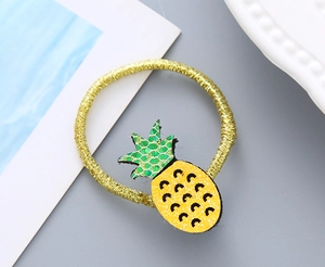 Détail d'un élastique à cheveux ananas scintillant avec finitions pailletées jaune et vert