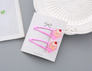 Détail de deux barrettes à cheveux rose crème glacée pour filles sur carte