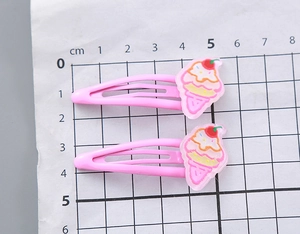 Vue détaillée de barrettes à cheveux roses avec glace, montrant la taille sur échelle