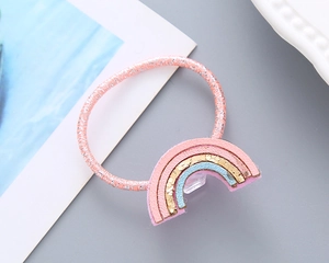 Détail de l'élastique rose avec pendentif arc-en-ciel mignon et fils argentés brillants