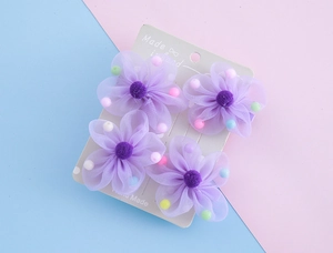Set mit 4 lila Tüll-Blumen-Haarspangen für Kinder mit bunten Perlen auf Karte
