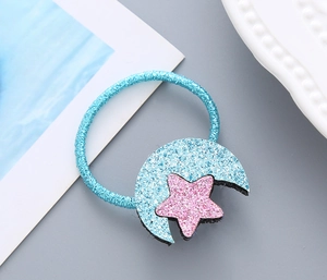 Détail d'élastique à cheveux bleu avec breloques lune et étoile à paillettes