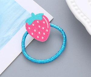 Détail d'un élastique à cheveux bleu vif avec un charme de fraise rose pailletée