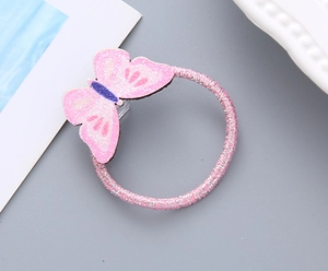 Détail d'un élastique à cheveux papillon rose avec paillettes et cordon métallisé
