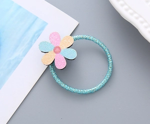 Détail d'un élastique à cheveux bleu avec une fleur rose pailletée pour fille