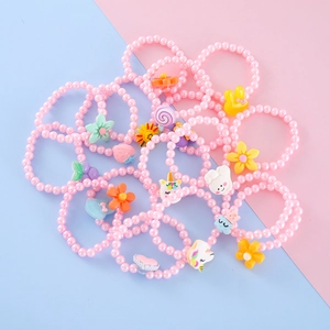 Detail of pink pearl elastic bracelets with cute resin cartoon charms for girls