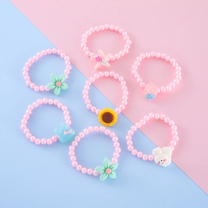 Detail of 7-piece pink beaded children's bracelets featuring cartoon charms and pearls