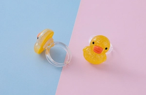 Vista dettagliata di un anello a forma di papera gialla in resina trasparente con glitter