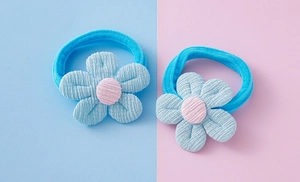 Vue détaillée de deux élastiques à cheveux fleurs tricotées bleues avec centre rose doux