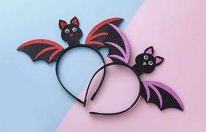 Detailed view of Halloween bat headbands with glittering red and purple wings for parties
