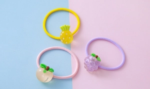 Close-up of cute cartoon fruit resin hair ties including pineapple peach and grape
