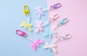 Flat lay of colorful acrylic bow pendants with beads for cute candy-style keychains