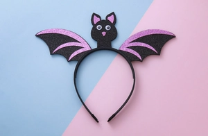 Close-up of Halloween bat headband featuring purple glitter wings and moving eyes decor