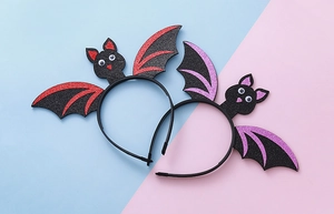 Detail view of Halloween bat headbands with red and purple glitter wings and cartoon eyes