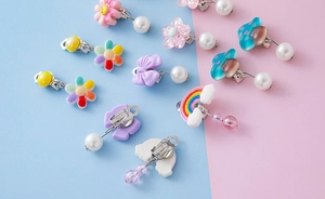 Detailed close-up of colorful resin cartoon clip-on earrings with rainbow and flower motifs