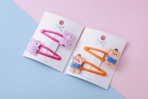 Detail of cute resin bear hair clips for kids in pink and orange vibrant colors