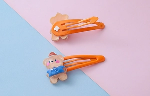 Close-up of cute resin bear hair clip with glitter detail and orange metal BB clip