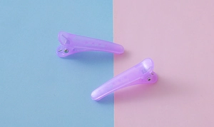 Détails de pinces à cheveux violettes translucides sur fond de blocs bleu et rose
